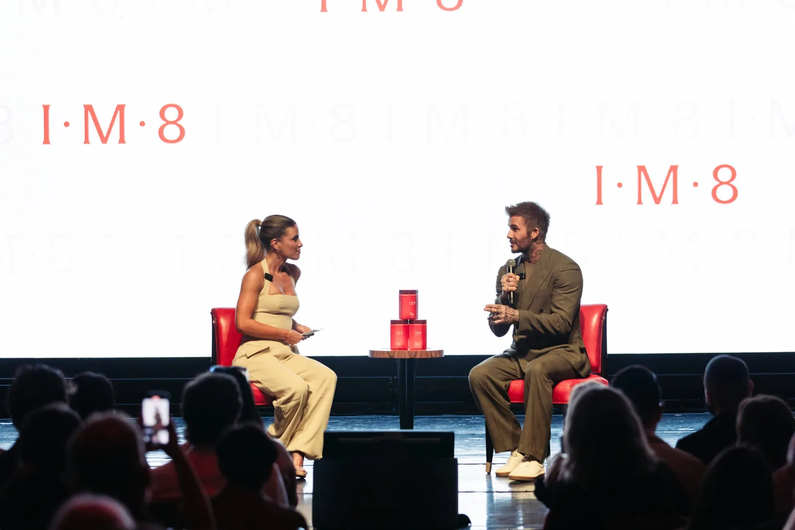 David Beckham and Kendall Toole on stage at IM8 Vibrante in Miami, IM8 logos on the screen behind them