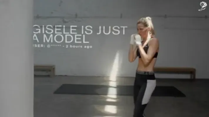 A comment about Gisele projected on the wall during her Under Armour ad.