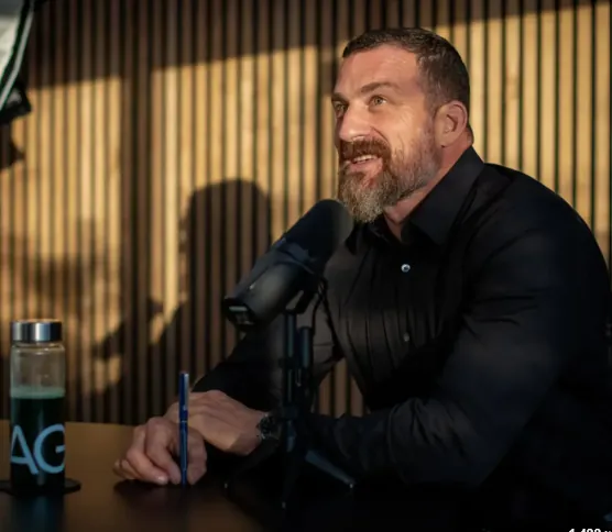 Andrew Huberman on his podcast, with an AG1 bottle on the desk