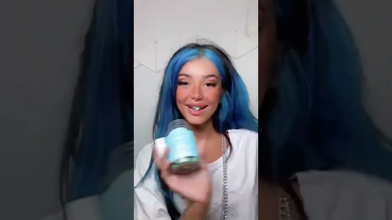 A creator holding the SugarBearHair bottle up to the camera in a video.