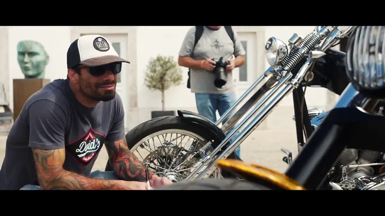A man in a cap working on a motorcycle in a garage