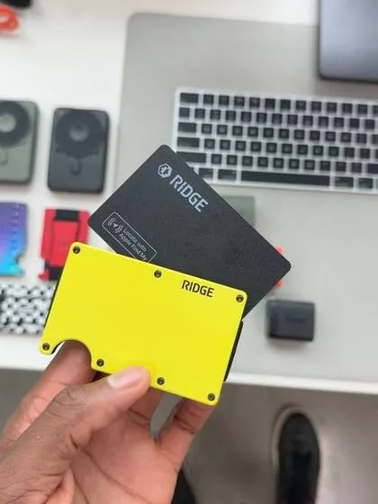 MKBHD's own Instagram post holding a black and a yellow Ridge wallet, both stamped RIDGE, over his tech desk