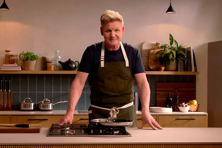 Gordon Ramsay at a stovetop in a HexClad apron, on HexClad's own Gordon Ramsay page, the real relationship behind the mailer