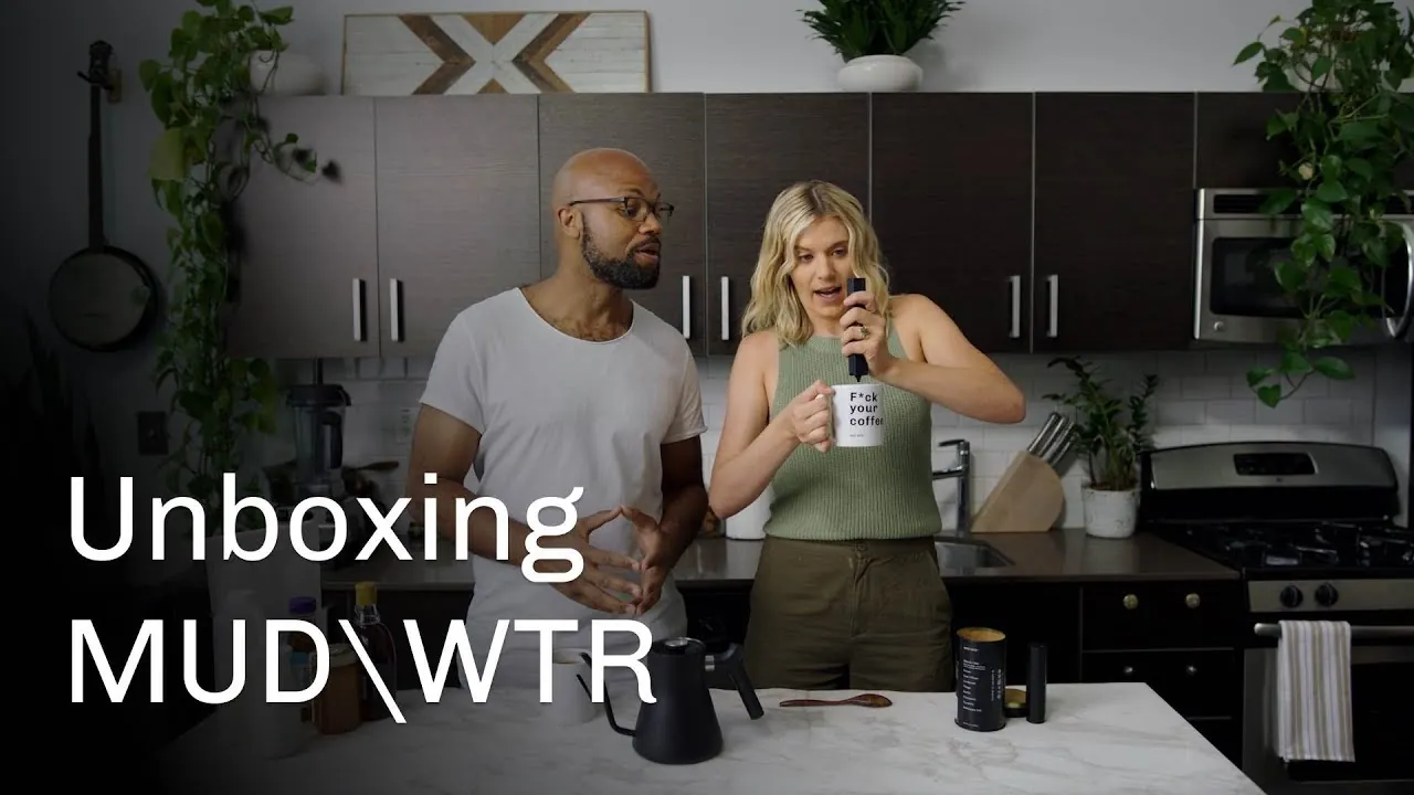 two real creators unboxing MUD\WTR together, the tin, a mug and a kettle on the counter