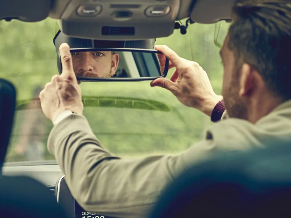 A dad adjusting the rear view mirror in the Renault Scenic campaign