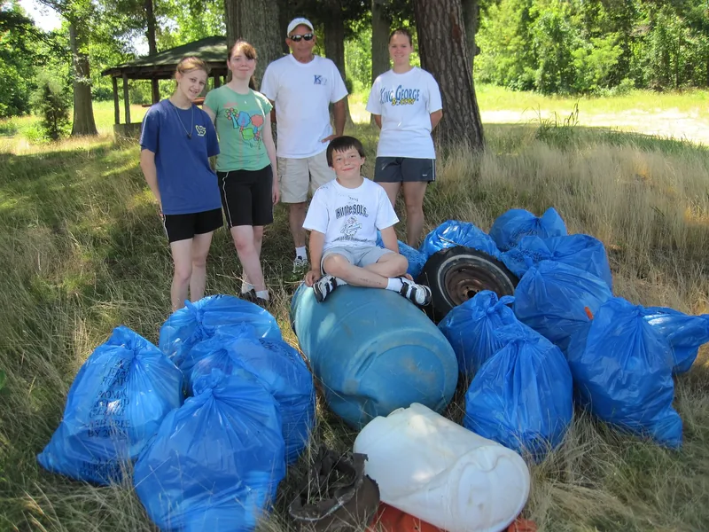 Volunteers standing by the bags of trash they cleared off a beach