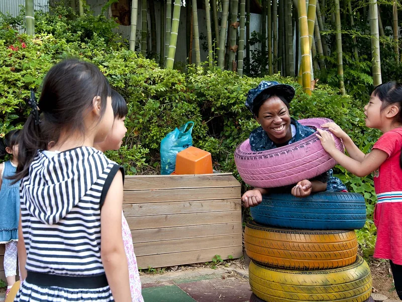 Children from a children's home in Korea playing outside with a volunteer