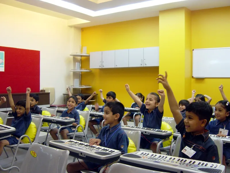 A class of young children in India raising their hands